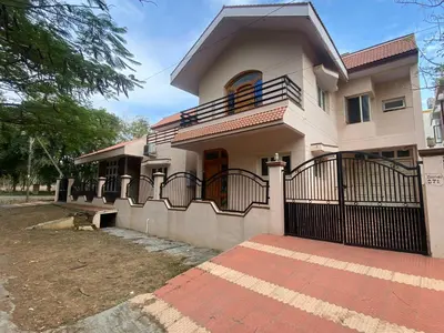 a house with a gate in front of it at Aasana A tranquil space by the hills in Mysore