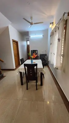 a dining room with a table and chairs at Aasana A tranquil space by the hills in Mysore