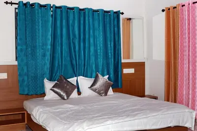 a bedroom with a bed with blue curtains and pillows at Angels Nest 3BR FF near Karlad Lake by Homeyhuts in Padinjarathara