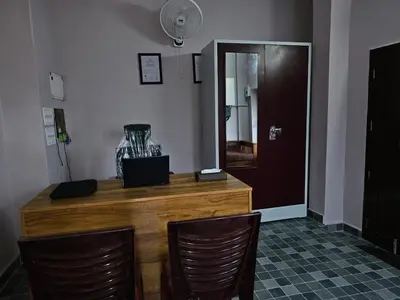 a wooden counter with two chairs and a mirror at Guruvayur Nest Homestay Duo in Guruvāyūr