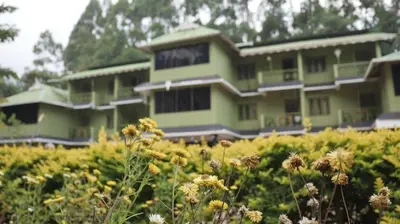 a green building with flowers in front of it at Nature Quite in Vattavada