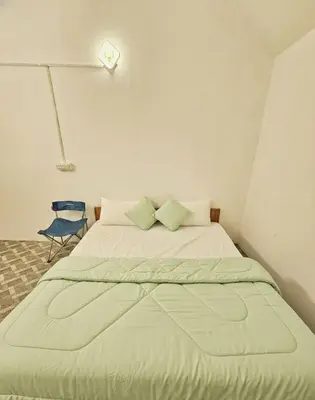a large bed in a room with a blue chair at Canvo Vattavada in Vattavada