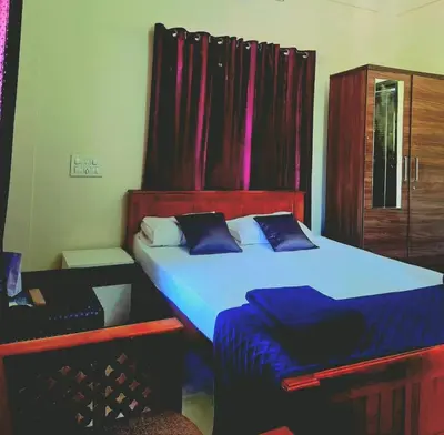 a bedroom with a large bed with blue sheets at Wayanad Pent House in Mananthavady