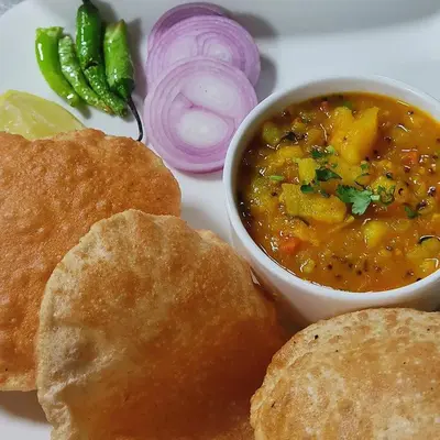 a plate of food with a bowl of soup and bread at Wayanad Pent House in Mananthavady