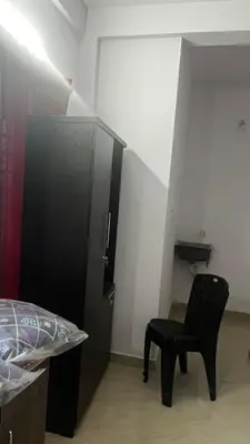 a bedroom with a black chair next to a bed at Aneesh Arcade in Kollengode