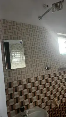 a bathroom with a sink and a tile wall at Aneesh Arcade in Kollengode