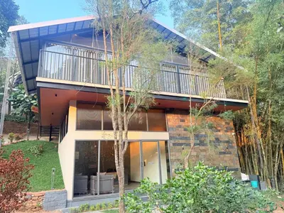 a house with a balcony on the side of it at Vythiri Greens Holiday Resorts in Vythiri