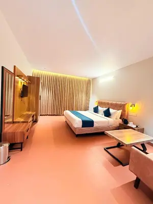 a bedroom with a bed and a couch and a table at Vythiri Greens Holiday Resorts in Vythiri
