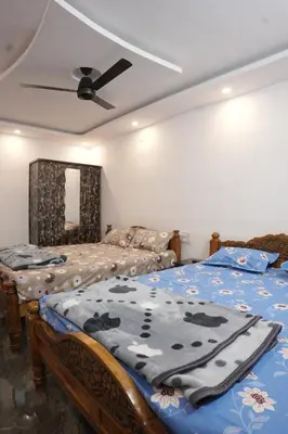 a bedroom with two beds and a ceiling fan at River view farm stay in Anaimalai
