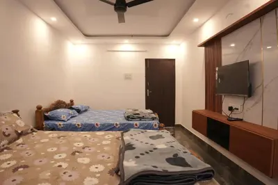 a bedroom with two beds and a flat screen tv at River view farm stay in Anaimalai