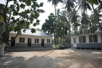 a building with a car parked in front of it at River view farm stay in Anaimalai