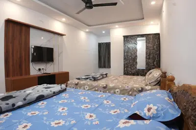 a bedroom with two beds and a flat screen tv at River view farm stay in Anaimalai