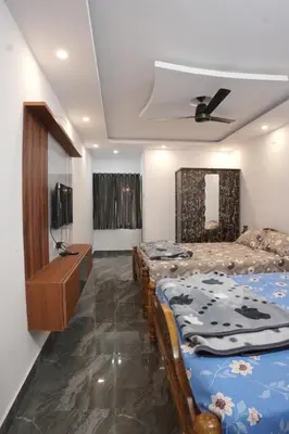 a bedroom with two beds and a television in it at River view farm stay in Anaimalai
