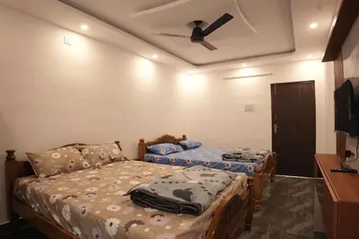 a bedroom with two beds and a ceiling fan at River view farm stay in Anaimalai