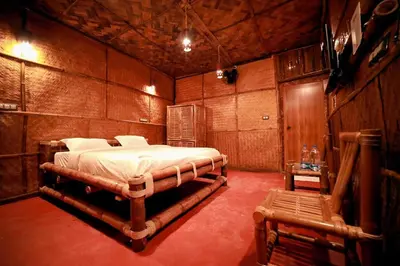 a bedroom with a bed in a wooden room at Bali Bamboo Resort in Padinjarathara