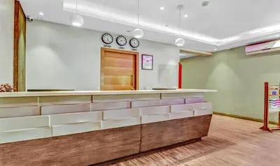 a waiting room with two clocks on the wall at Medora Hotel by Rak Rooms in Kozhikode