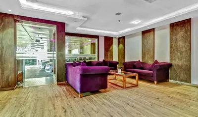 a living room with purple couches and a table at Medora Hotel by Rak Rooms in Kozhikode