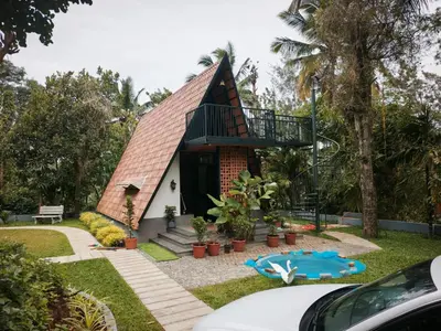 a small house with a balcony on top of it at Whispering Bamboos Attapadi Palakkad in Palakkad