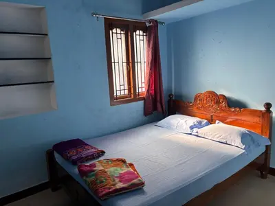 a bed in a blue room with a window at The Retreat in Vālpārai