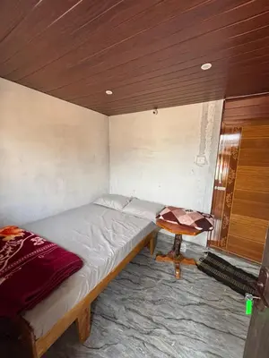 a small bedroom with a bed and a table at The Retreat in Vālpārai