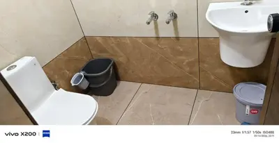 a bathroom with a toilet and a sink and a trash can at Pranavam homestay in Guruvāyūr