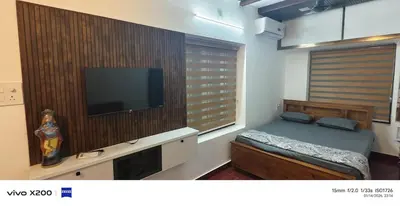 a bedroom with a bed and a flat screen tv at Pranavam homestay in Guruvāyūr