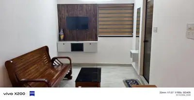 a living room with a bench and a flat screen tv at Pranavam homestay in Guruvāyūr