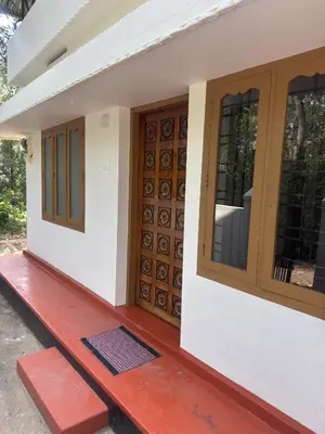 a house with wooden doors and a red porch at Hibisco Hideout in Meenangadi