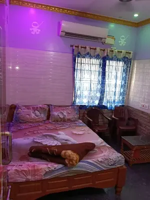 a bedroom with a large bed with pink lighting at VR Residency in Wodapatti