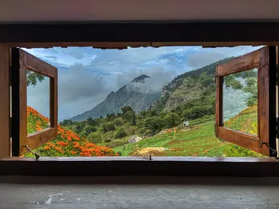 an open window with a view of a mountain at Hullathy by Red Earth in Ooty