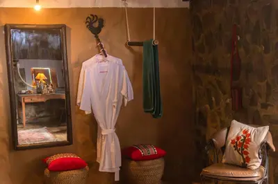 a robe hanging on a wall next to a mirror at Hullathy by Red Earth in Ooty