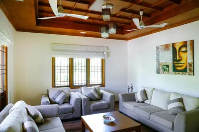 a living room with two couches and a table at River Whisper Homestay in Cochin