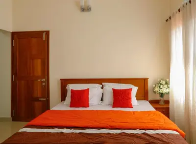 a bedroom with a bed with two red pillows at River Whisper Homestay in Cochin