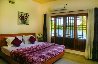 a bedroom with a bed with purple sheets and a window at River Whisper Homestay in Cochin