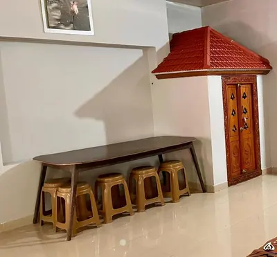 a wooden bench with stools in a room at Bean & Breeze in Suntikoppa