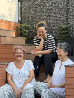 three women sitting on the steps of a building at Oblue Private Pool Villa in Cherai Beach