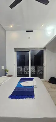 a large white bed with a blue blanket on it at Love Nest Inn Homestay in Agali