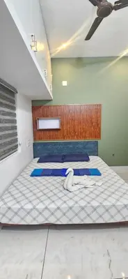 a bedroom with two beds with a ceiling at Love Nest Inn Homestay in Agali