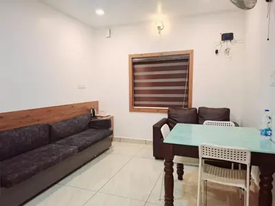 a living room with a couch and a table at Tender leaf inn in Koroth