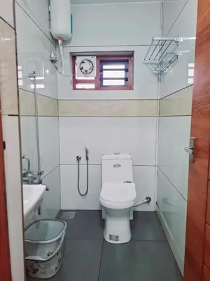 a bathroom with a toilet and a sink and a window at Tender leaf inn in Koroth