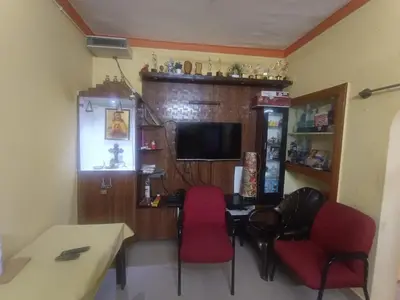 a room with a table and chairs and a television at Holy Family Nest 2 in Mysore