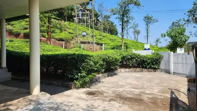 a house with a hill in the background at The Bear's Lair 2BHK Chembra Peak View in Vythiri