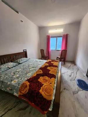 a bedroom with a bed with a quilt on it at Brooklyn Homestay in Vattavada