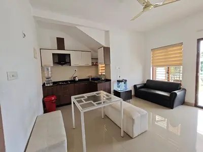 a living room with a glass table and a couch at Athirappilly resort villa in Athirappilly
