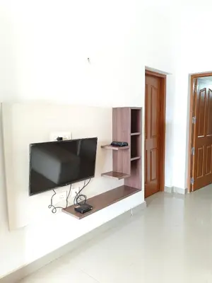 a flat screen tv on a wall in a living room at Athirappilly resort villa in Athirappilly