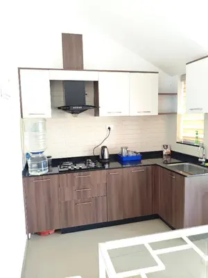 a kitchen with wooden cabinets and a stove top oven at Athirappilly resort villa in Athirappilly
