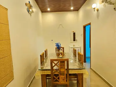 a dining room with a marble table and chairs at Mamoksha Riverdale in Padinjarathara