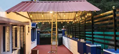 a pergola with string lights on a patio at White House Cottage in Ooty