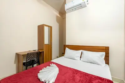 a bedroom with a bed with a red blanket at Grape Rooms in Perintalmanna