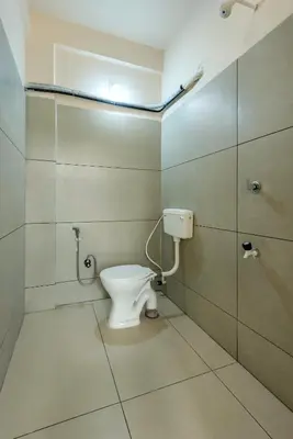 a bathroom with a toilet and a shower at Grape Rooms in Perintalmanna